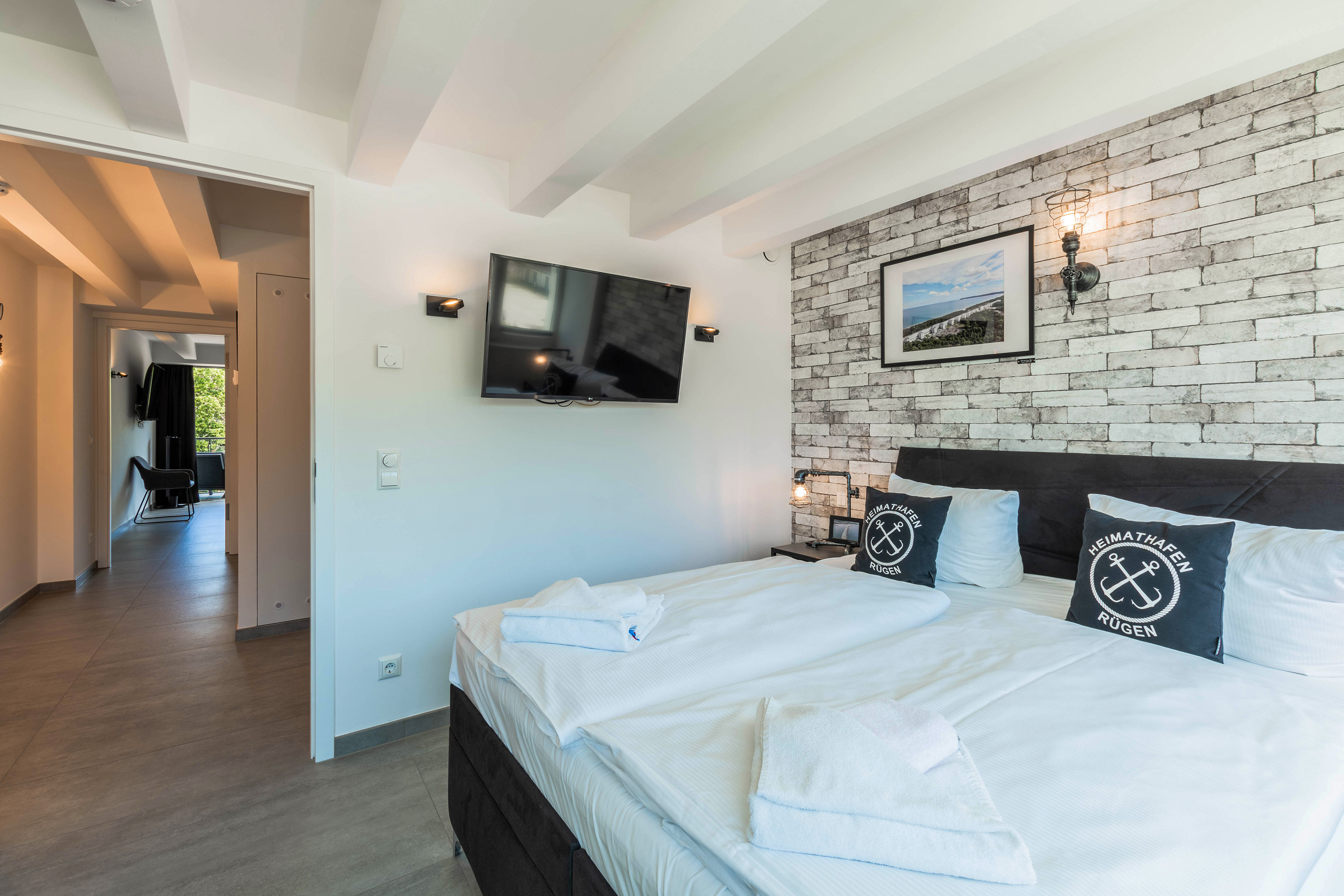Schlafzimmer mit TV und Blick in den Flur